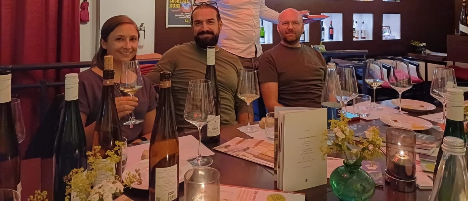 Kleine Weinrunde mit Gästen an einem stilvoll gedeckten Tisch